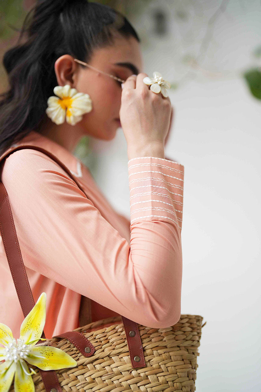 SS25DC-2573 Peach 2-piece ensemble featuring an embroidered kurta with delicate floral threadwork on the neckline and sleeves, paired with solid trousers.