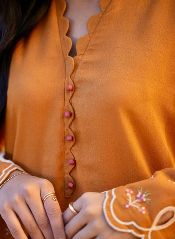 FW25DC-2881 Mustard 2-piece karandi ensemble with white and orange embroidery and scalloped neckline.