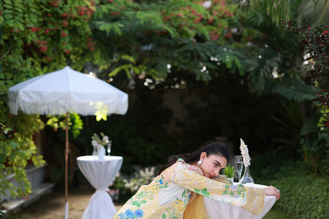 Soft yellow silk ensemble featuring floral and paisley motifs in blue, green, and peach tones.